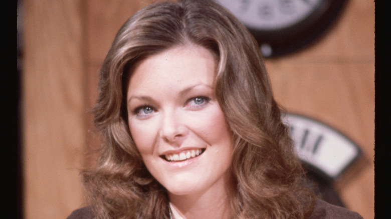 Jane Curtin smiling while on the Weekend Update desk during an episode of Saturday Night Live