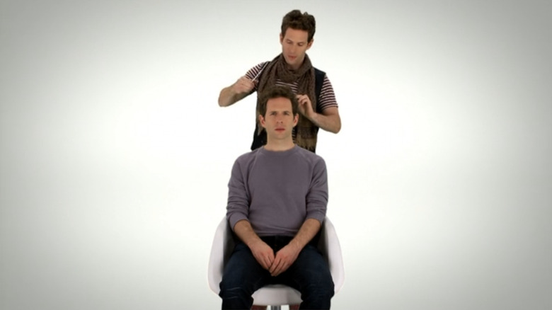 Glenn Howerton as Dennis sitting in a chair while British Dennis cuts his hair in a dreamscape on It's Always Sunny in Philadelphia