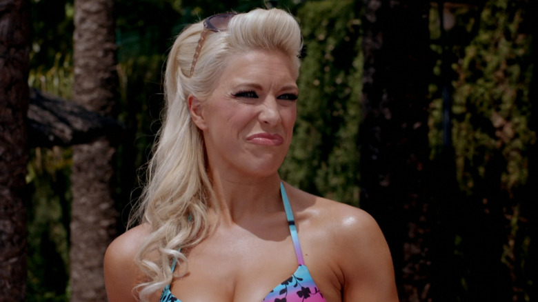 Hannah Waddingham as Tanya Dyke in Benidorm with a blond ponytail, wearing a blue and pink bikini and sunglasses on her head.