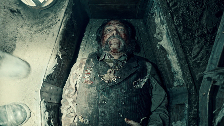 Masson lying in a coffin with his eyes open on Guillermo del Toro's Cabinet of Curiosities