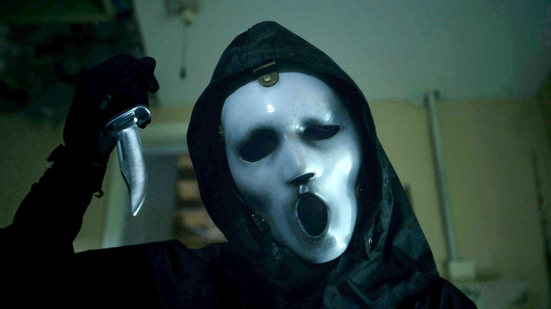 Ghostface from MTV's Scream looking at a victim with his knife raised