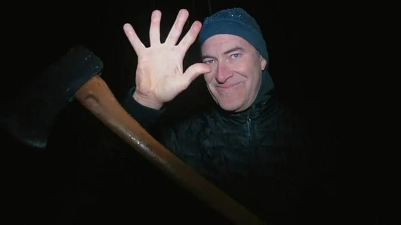 Josef showing off an empty hand and holding an axe with the other hand in The Creep Tapes