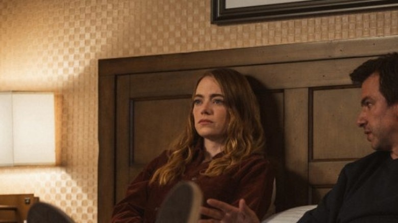 Whitney and Asher Siegel sitting in bed together as Asher looks over and speaks to her in The Curse episode "Young Hearts"