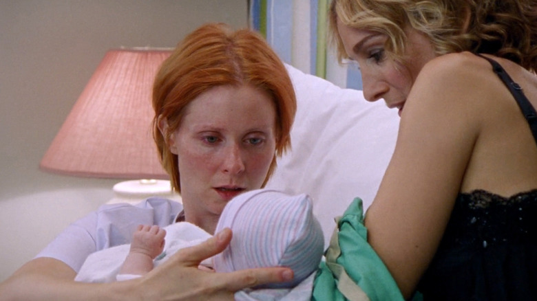 Miranda holding her baby, handed to her by Charlotte in Sex and the City