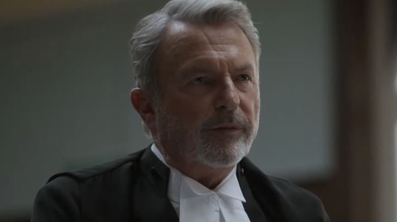 Sam Neill as Brett Colby with gray hair and a gray beard in The Twelve
