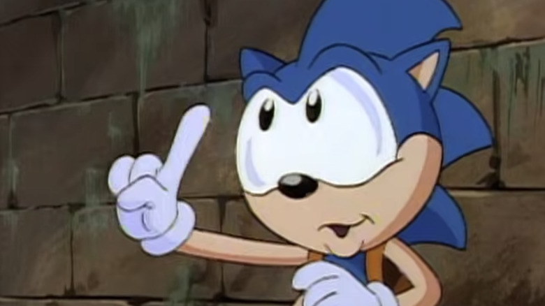 A blue anthropomorphic hedgehog with white gloves holds one finger up.