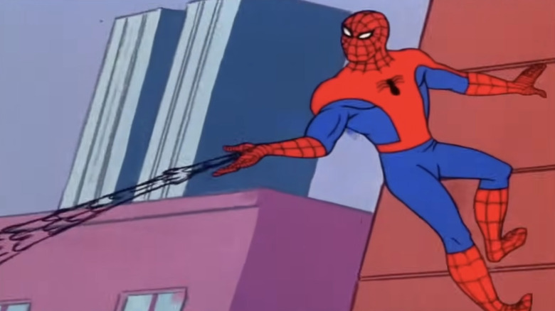 Spider-Man holding onto the wall of a building and spinning a web out of his wrist.