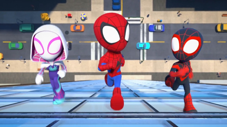 Gwen Stacy as Ghost-Spider, Peter Parker as Spidey, and Miles Morales as Spin running up the side of a building.