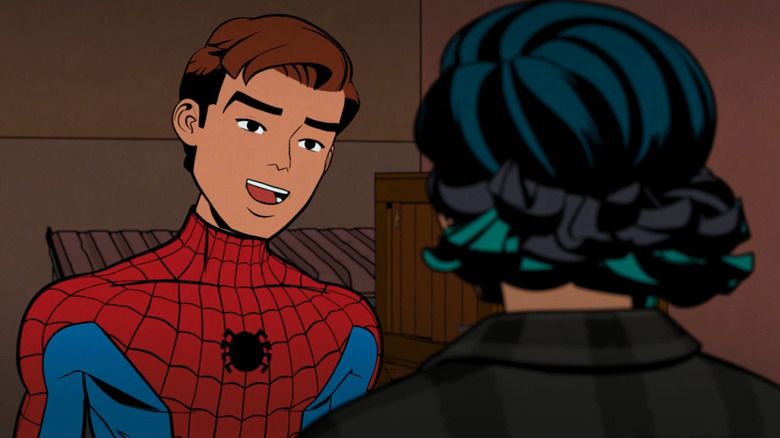Peter Parker wearing a red and blue costume, with a small black spider logo on his chest. He isn't wearing a mask and he has brown hair with a floppy fringe. He's speaking to a girl with blue, green, and black hair. She's wearing a black plaid shirt and has her back to the camera.