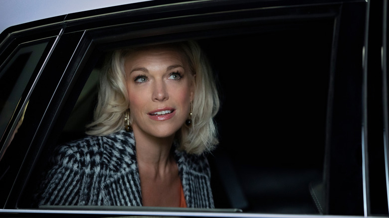 Rebecca Welton smiling with awe as she looks out of a car window