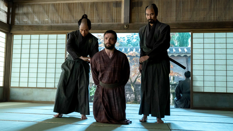 John Blackthorne kneels besides two samurai in "Shōgun" (2024