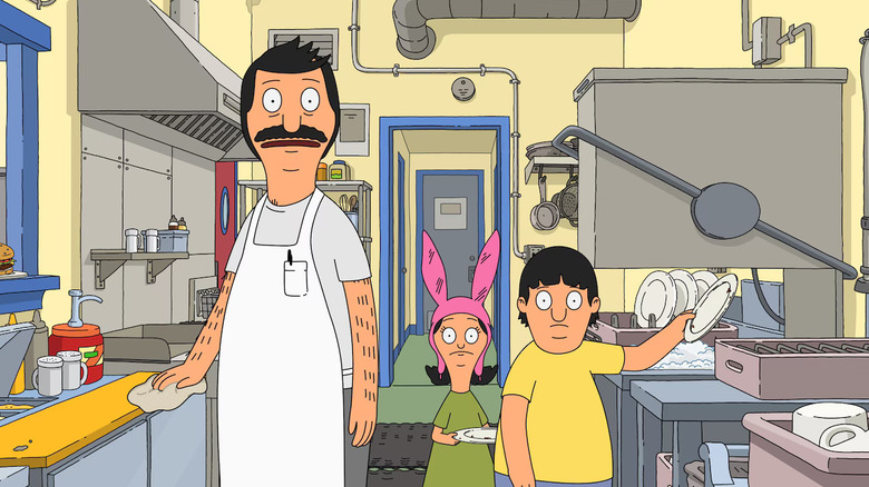 Bob Belcher wipes down the counter while staring slack jawed with his kids Louise and Gene behind him in "Bob's Burgers"
