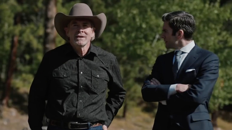 On the left, Will Patton wearing a black shirt and a light brown cowboy hat. On the right, Wes Bentley as Jamie Dutton wearing a dark blue suit with a white striped shirt and a gray tie. He has graying black hair.