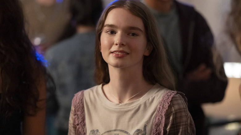 Summer H. Howell as Carrie smiling at a party in a scene from the series "Carrie."
