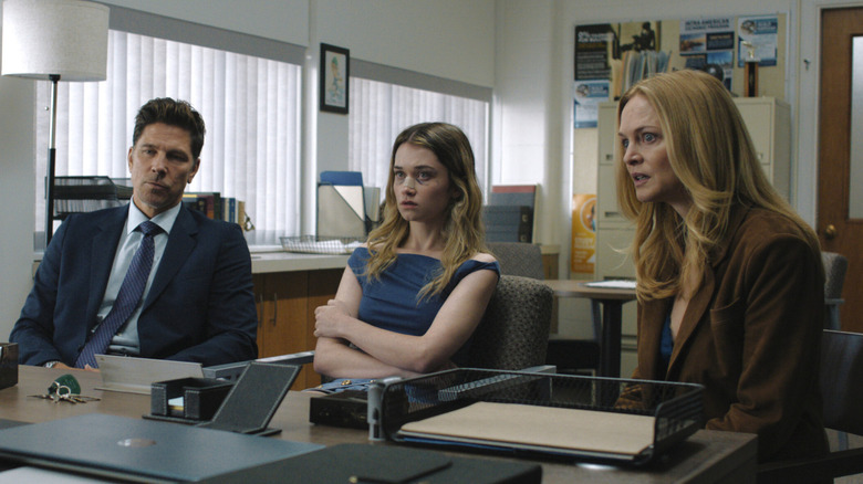 Michael Trucco as John, Alison Thornton as Chris, and Heather Graham as Mrs. Hargensen sitting next to each other at the principal's office with upset expressions in a scene from "Carrie."