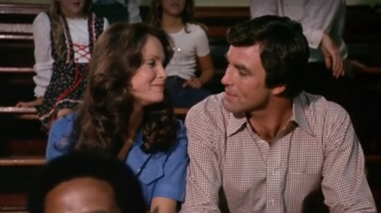 Kelly Garrett and Dr. Samuelson sitting side-by-side in bleachers at basketball game