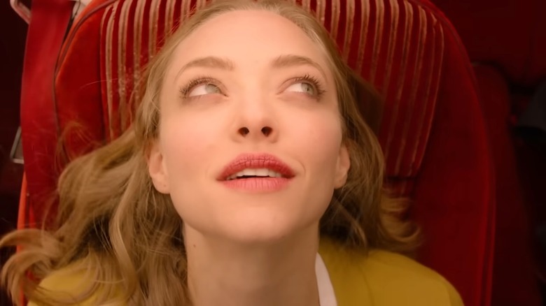 Amanda Seyfried wearing a yellow top and sitting on a red car seat looking up in "Twin Peaks."
