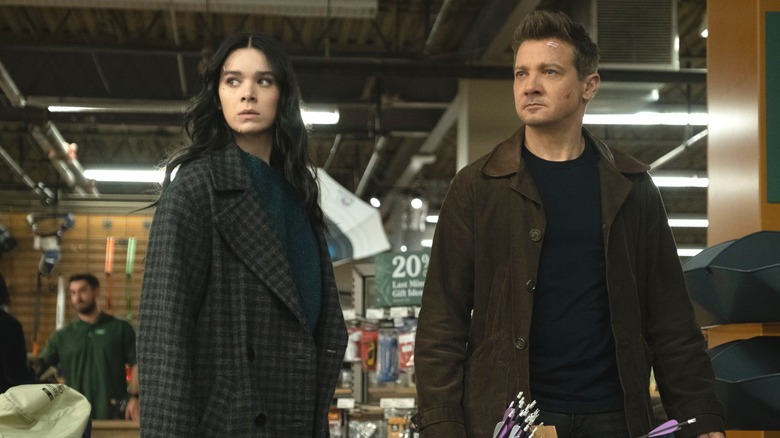 Kate Bishop and Hawkeye wearing dark clothing and holding arrows in a store in "Hawkeye."