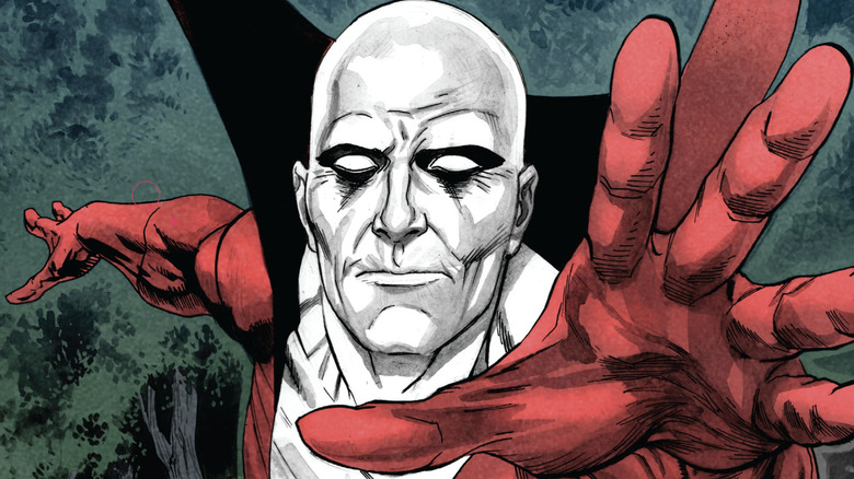 An illustration of Deadman, he's pale white and bald with completely blank eyes. He's wearing a red outfit with a large collar that is as high as his eyes. He is reaching out with his red-gloved hands towards the camera.