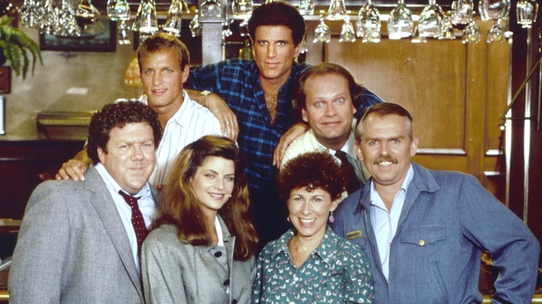 the cast of "Cheers" (1982) pose for a photo on set