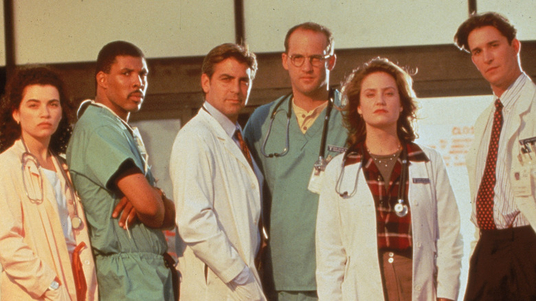 Cast of "ER" posing together while looking at the camera.