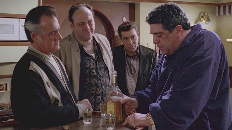 Paulie (Tony Sirico), Tony Soprano (James Gandolfini), Silvio (Steven Van Zandt) all looking at Big P**** Bonpensiero (Vincent Pastore) who is holding a bottle in The Sopranos