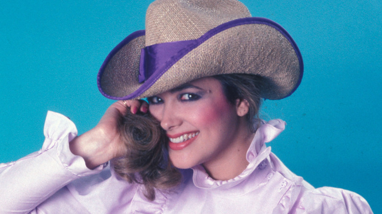 Janine Turner posing and wearing a hat