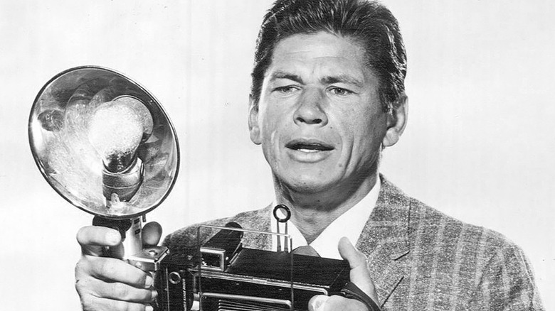 Mike Kovac holding a camera in "Man With a Camera" (1958)