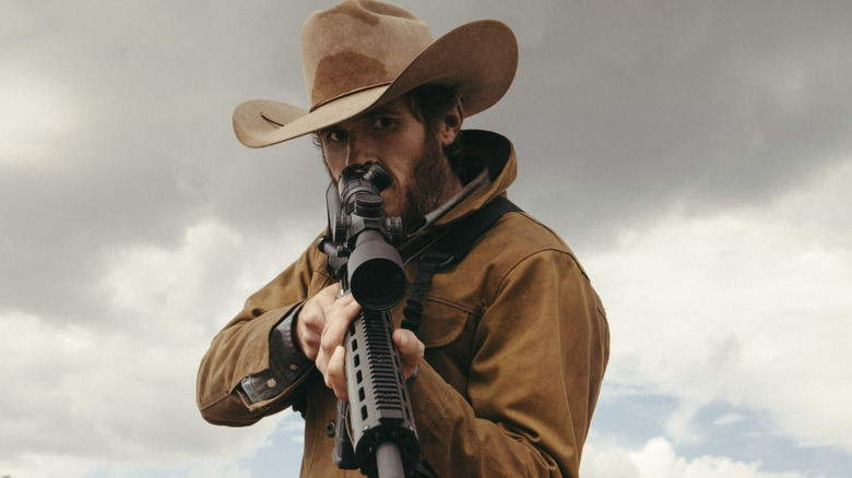 Dave Annable as Lee Dutton, holding a rifle in Yellowstone.