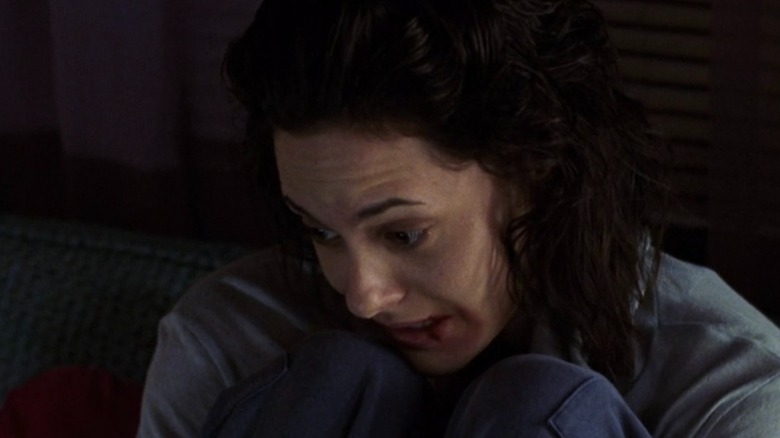Cheryl Avery holding her knees with blood around her lip