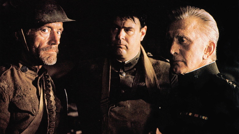 Kirk Douglas, Dan Akroyd, and Lance Henriksen standing in darkness in Tales from the Crypt