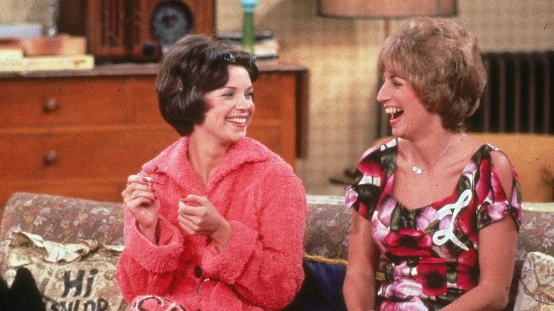 Laverne and Shirley laugh on their couch at home in "Laverne & Shirley" (1976)