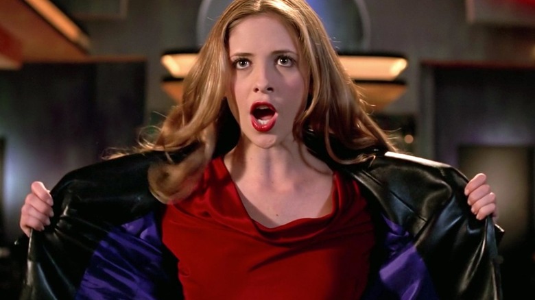 Buffy (Sarah Michelle Gellar) sings mid-song, her mouth forming an "O," while wearing a red shirt and holding her black leather jacket open