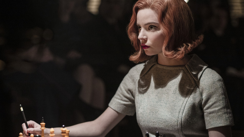 Beth Harmon playing chess in a dark tournament room in The Queen's Gambit (2020)