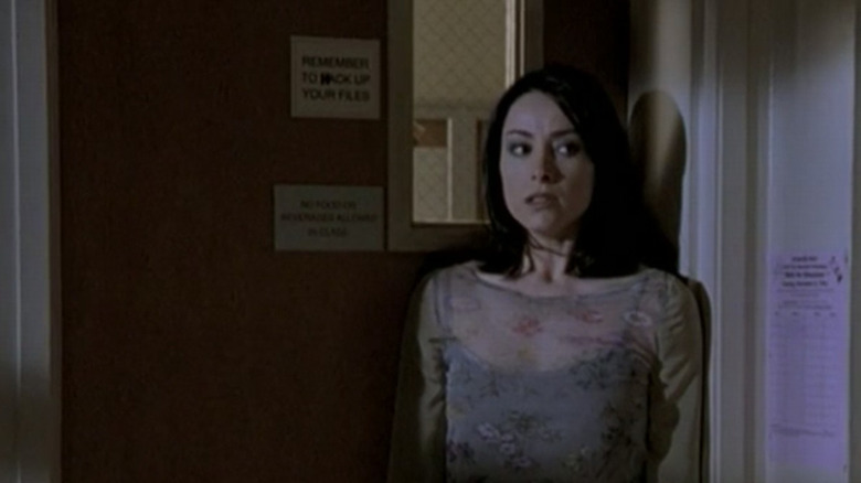 Jenny Calendar trying to sneak away from Angelus, edging toward a door, in Buffy the Vampire Slayer Season 2 (1998)