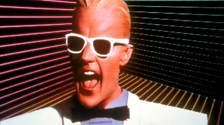 Max Headroom smiling wide with sunglasses on in Max Headroom (1987)
