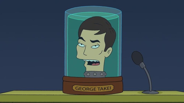 George Takei's head sitting on a table and talking into a microphone in Futurama