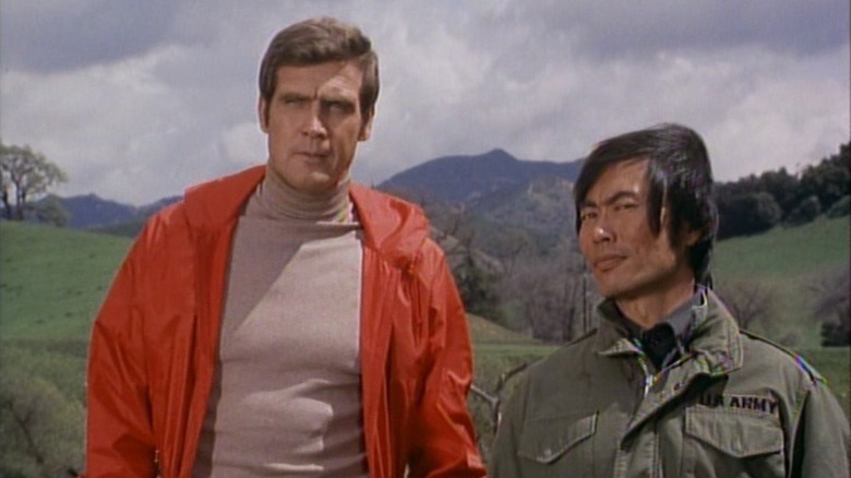 Steve Austin standing next to Chin-Ling, who is looking out skeptically, in The Six Million Dollar Man