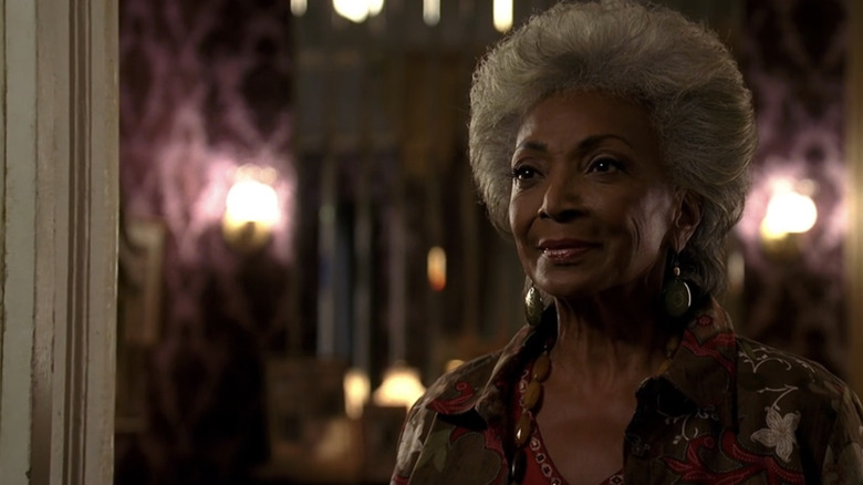 Nana Dawson smiling softly at her open front door in "Heroes" (2006)