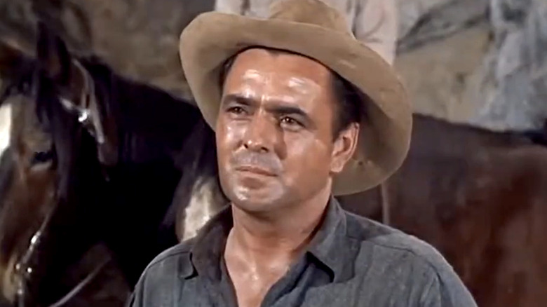 Bill Collins wearing a cowboy hat in front of a horse in Bonanza