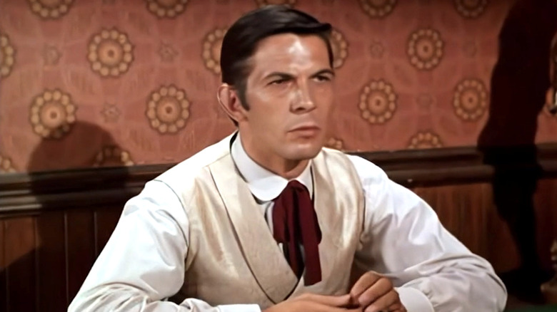 Freddy sitting at a table in a saloon in Bonanza