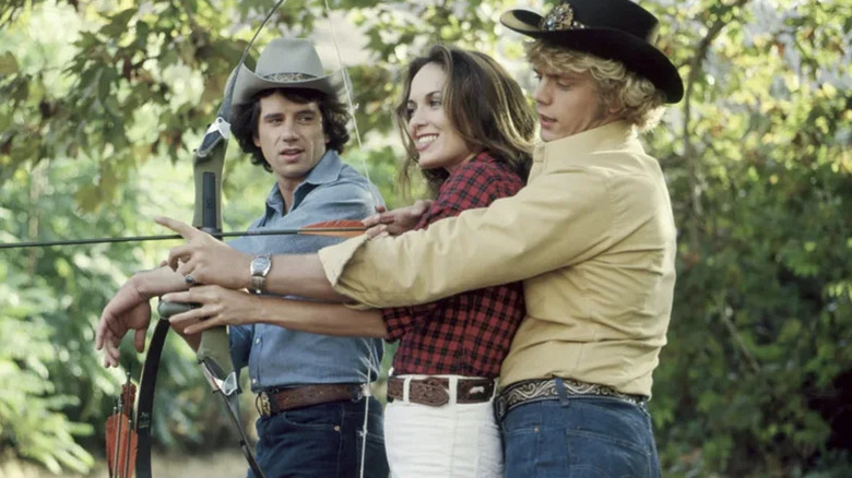 Luke, Daisy, and Bo Duke doing archery on The Dukes of Hazzard