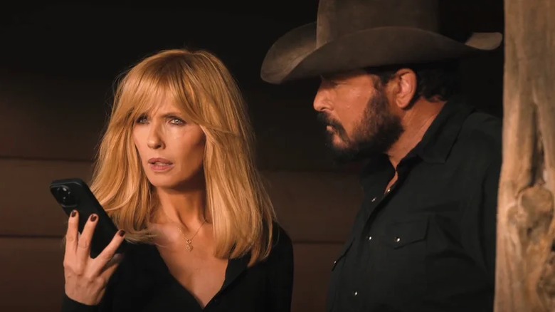 Beth Dutton holding a phone and Rip Wheeler looking at Beth on Dutton Ranch