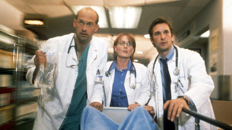 Mark Greene, Kerry Weaver, and John Carter push gurney on "ER"