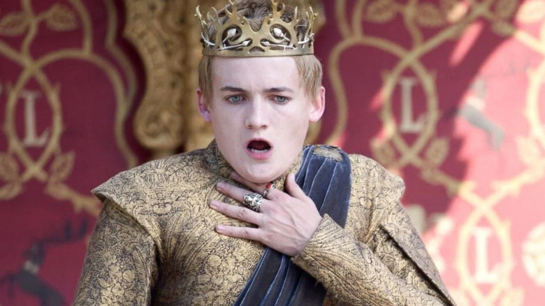 Jack Gleeson as Joffrey Baratheon, choking on Game of Thrones.