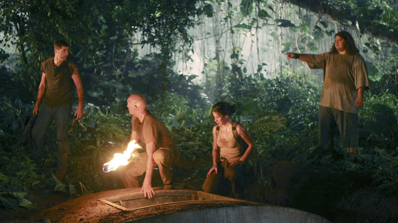 Jack Shephard, John Locke, Kate Austen, and Hurley Reyes standing around the hatch in Lost