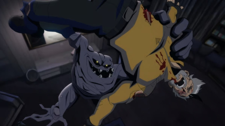 Clayface, a gray sludge monster with yellow eyes and pointed teeth, is holding Rick Flagg Sr. in the air — he's dressed in a yellow shirt and has gray hair.
