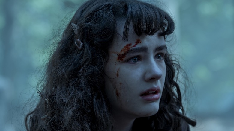 Clara Stack as Lilly Bainbridge with a startled expression and a blood-stained face in "IT: Welcome to Derry."
