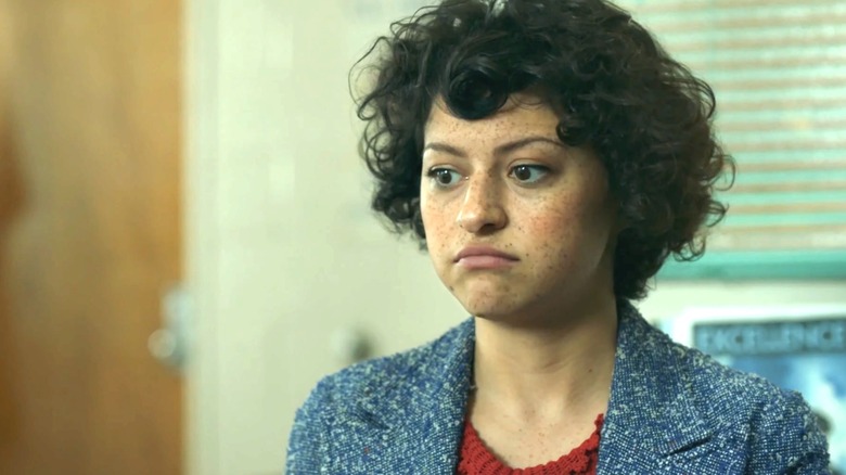 Dory sits in a room with a red top and blue jacket in "Search Party."