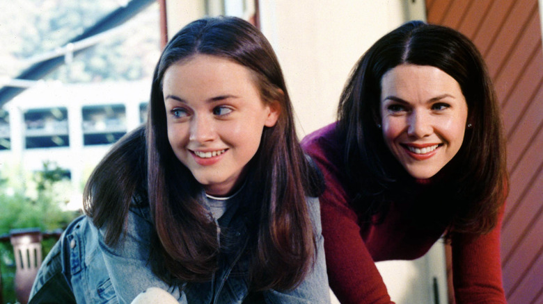 Rory and Lorelai Gilmore standing next to each other and smiling in Gilmore Girls